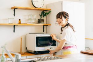 Femme devant son four micro-ondes