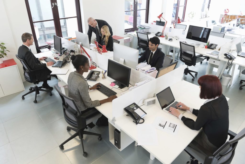 Vue d'un open space avec des collaborateurs en train de travailleurs sur leurs ordinateurs