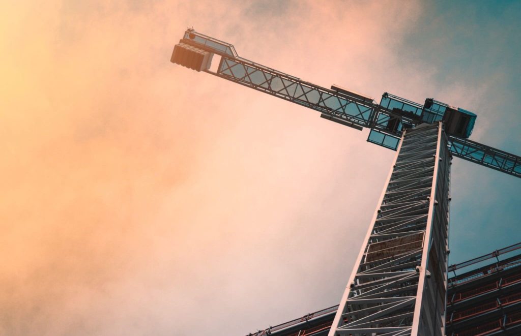 Vue d'une grue de chantier devant un immeuble à la tombée du jour