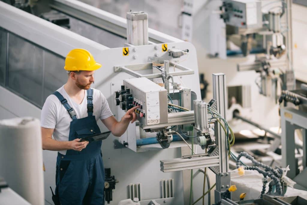 Vue d'un technicien en train de manipuler une machine industrielle