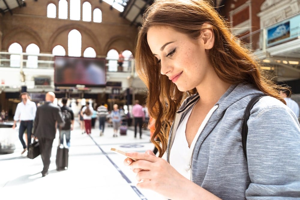 Femme sur son téléphone portable dans un hall de gare