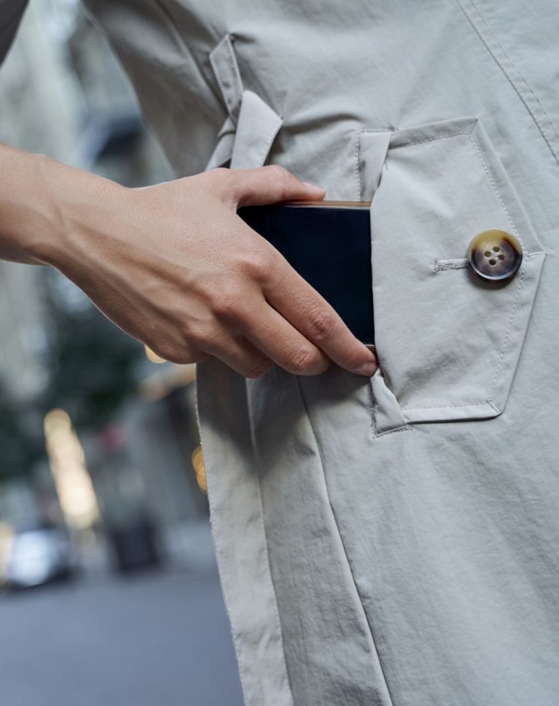 Téléphone portable glissé dans une poche de veste longue